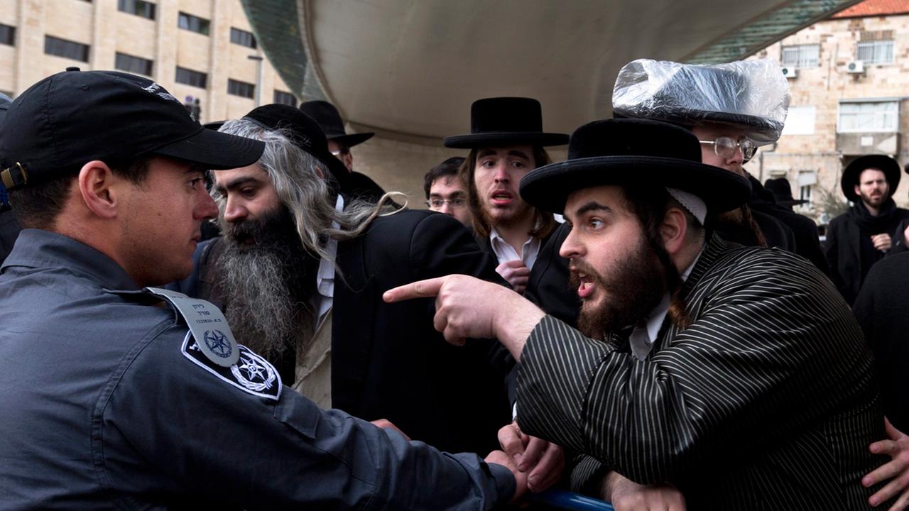 Hinter einer Absperrung beschimpfen ultraorthodoxe Juden in Jerusalem am 06.02.2014 die israelische Polizei. Hinter einer Absperrung beschimpfen ultraorthodoxe Juden in Jerusalem am 06.02.2014 die israelische Polizei.
