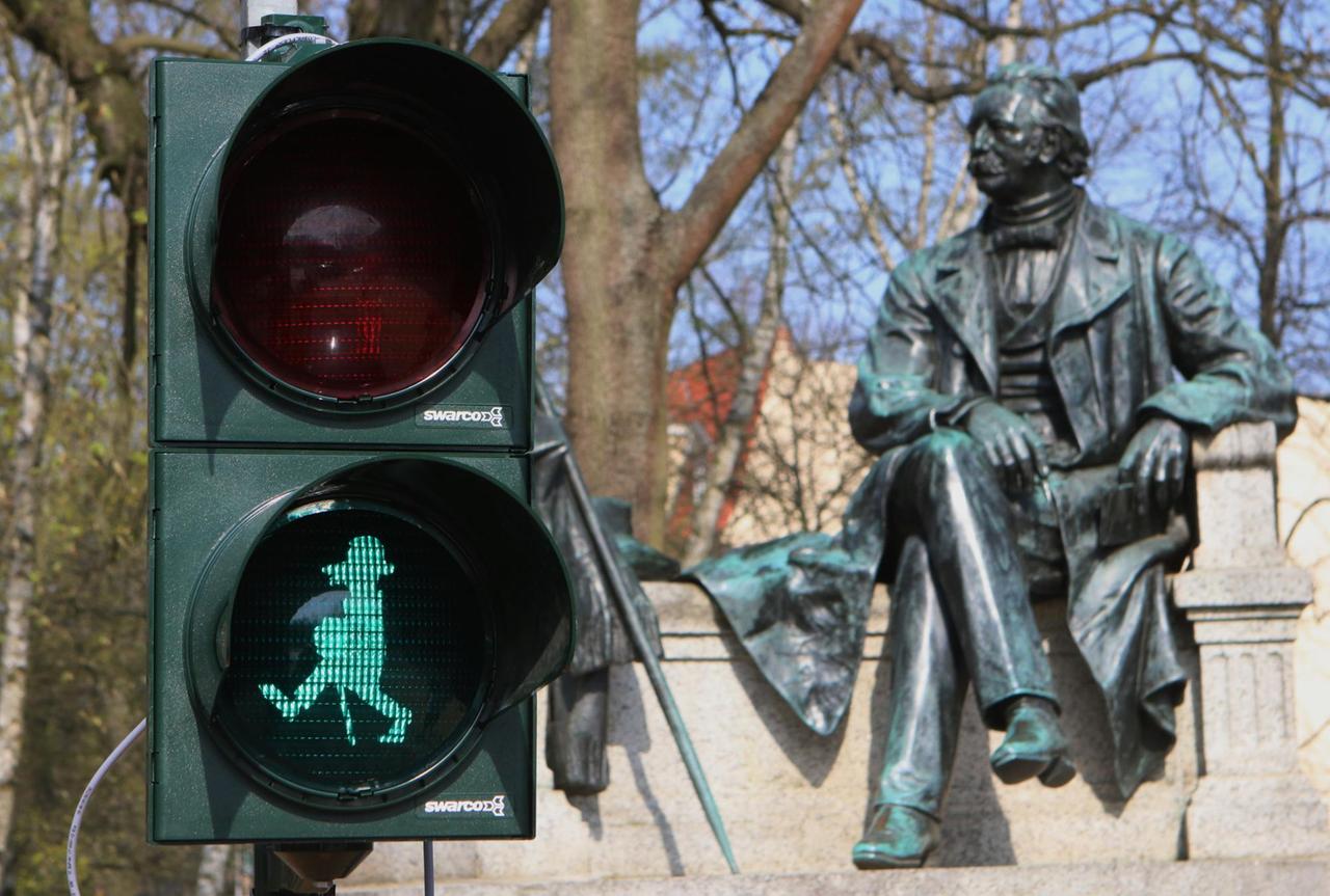 Vor dem Fontane-Denkmal am Fontaneplatz in Neuruppin steht eine Fußgängerampel mit einem Abbild des Schriftstellers Theodor Fontane als Ampelmännchen. Vor dem Fontane-Denkmal am Fontaneplatz in Neuruppin steht eine Fußgängerampel mit einem Abbild des Schriftstellers Theodor Fontane als Ampelmännchen.