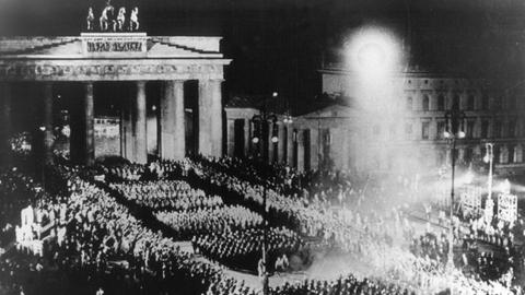 Für einen NS-Film nachgestellte Szene des Fackelzugs der SA durch das Brandenburger Tor, mit dem die Nationalsozialisten am 30.01.1933 die Machtübernahme feierten (Archivbild vom Sommer 1933).