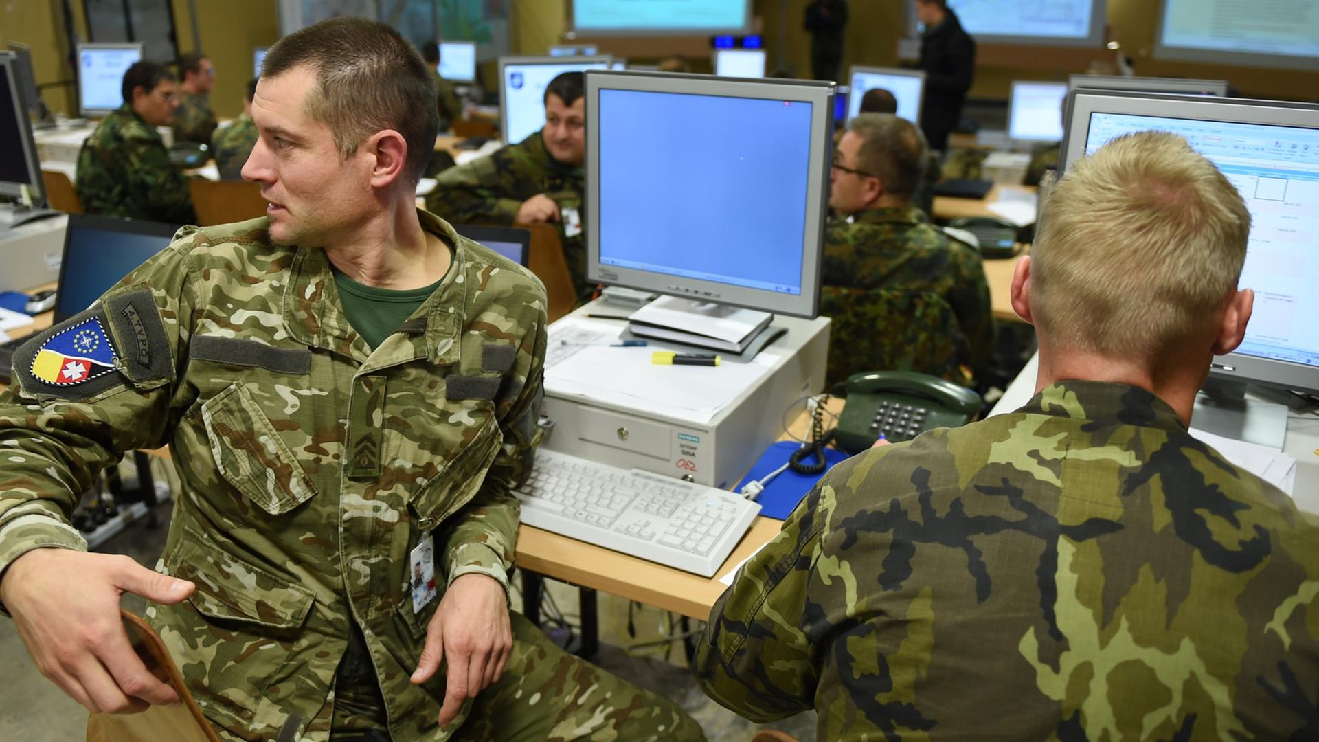 Zwei Soldaten aus Tschechien sitzen am 22.10.2014 in Stetten am kalten Markt (Baden-Württemberg) während der Bundeswehr-Übung "United Endeavour" im in der Operationszentrale an ihren Computern. Zwei Soldaten aus Tschechien sitzen am 22.10.2014 in Stetten am kalten Markt (Baden-Württemberg) während der Bundeswehr-Übung "United Endeavour" im in der Operationszentrale an ihren Computern.