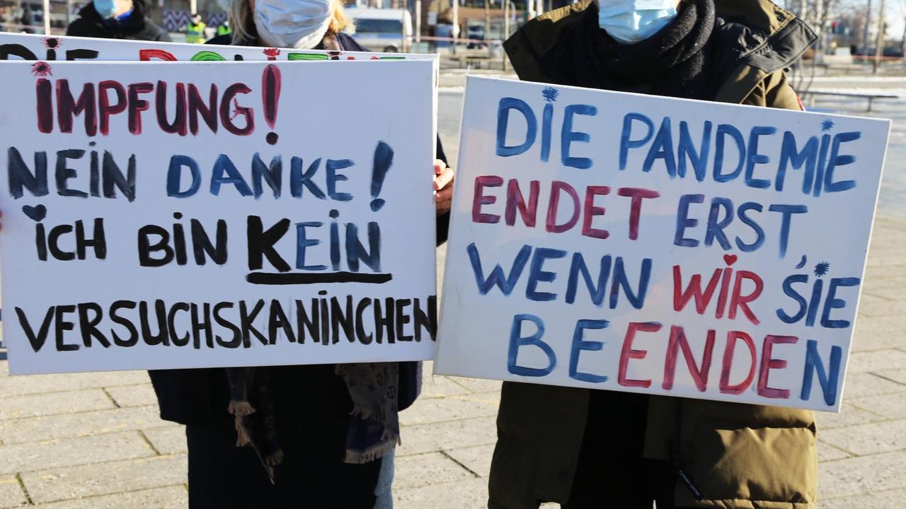 Zwei Personen halten Plakate mit der Aufschrift: Impfung - nein Danke! Ich bin kein Versuchskaninchen." und "Die Pandemie endet erst, wenn wir sie beenden." Demonstration gegen die Coronamaßnahmen in Mannheim. Zwei Personen halten Plakate mit der Aufschrift: Impfung - nein Danke! Ich bin kein Versuchskaninchen." und "Die Pandemie endet erst, wenn wir sie beenden." Demonstration gegen die Coronamaßnahmen in Mannheim.