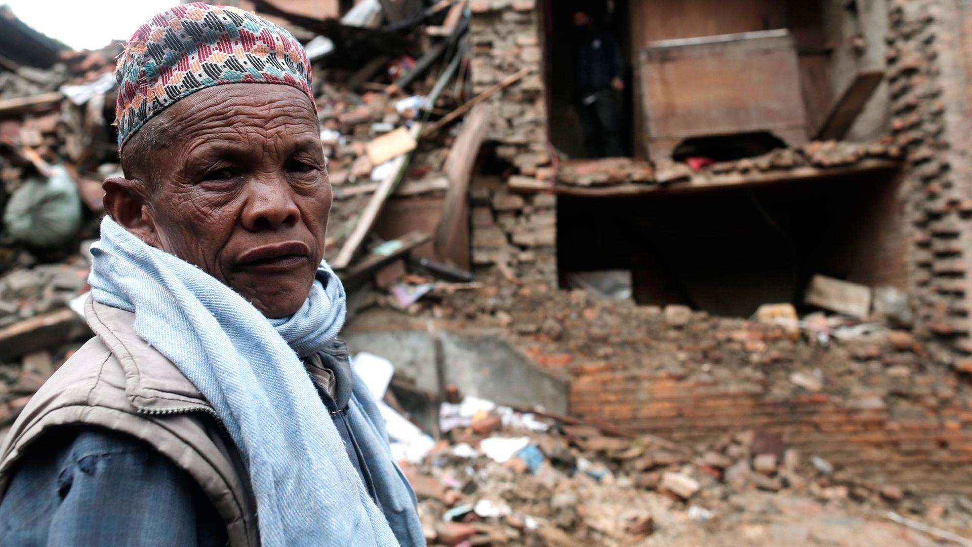 Ein Mann steht vor seinem zerstörten Haus in Kathmandu/Nepal