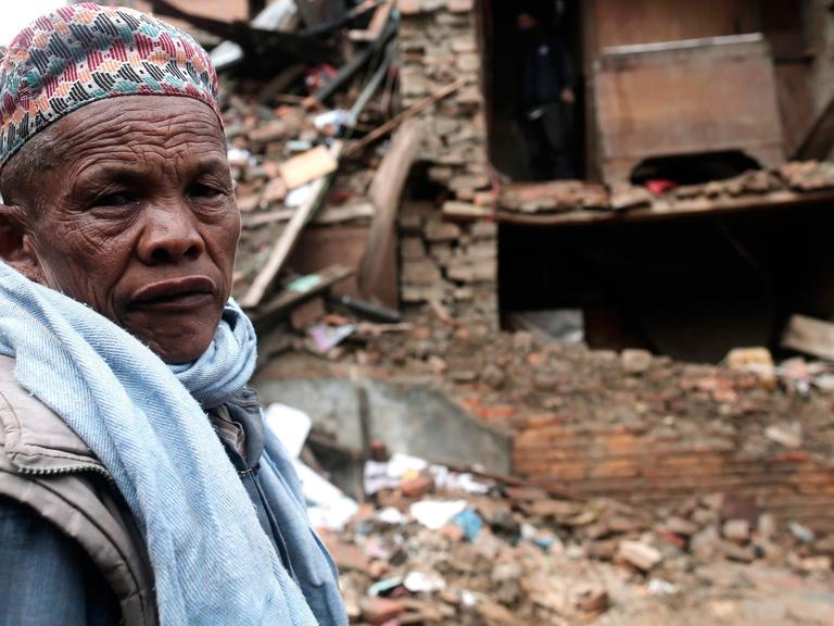 Ein Mann steht vor seinem zerstörten Haus in Kathmandu/Nepal