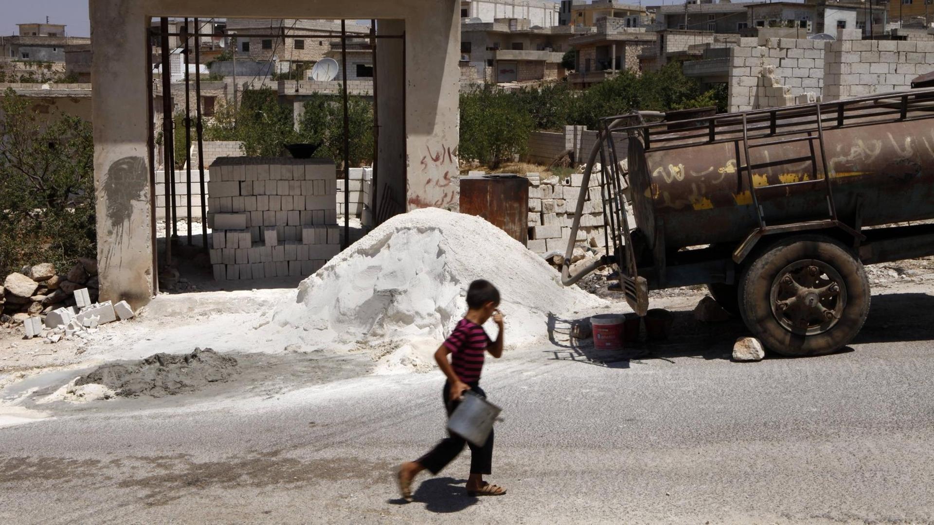 Ein Junge läuft vor eine Baustelle entlang in der Provinz Idlib, Syrien. Ein Junge läuft vor eine Baustelle entlang in der Provinz Idlib, Syrien.