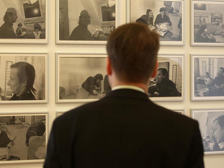 Ein Mann betrachtet Fotografien aus der Serie "Kirchfeldstraße, Düsseldorf" von Sigmar Polke in der Ausstellung vom Museum Morsbroich.