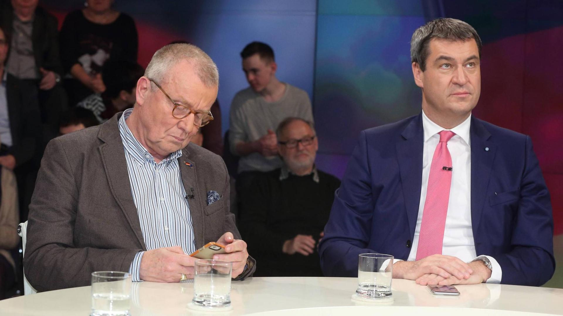 Ruprecht Polenz (Ehemaliger Vorsitzender des Auswärtigen Ausschusses des Deutschen Bundestages, CDU) mt Markus Söder (Bayerischer Staatsminister der Finanzen, für Landesentwicklung und Heimat, CSU) in einer Talkshow. Polen schaut auf sein Handy. Söders schweift ab. Auch sein Handy liegt vor ihm. Ruprecht Polenz (Ehemaliger Vorsitzender des Auswärtigen Ausschusses des Deutschen Bundestages, CDU) mt Markus Söder (Bayerischer Staatsminister der Finanzen, für Landesentwicklung und Heimat, CSU) in einer Talkshow. Polen schaut auf sein Handy. Söders schweift ab. Auch sein Handy liegt vor ihm.