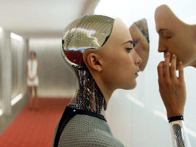 Im Still aus "Ex Machina" berührt Alicia Vikander in ihrer Rolle als Roboter das Gesicht eines anderen Roboters.