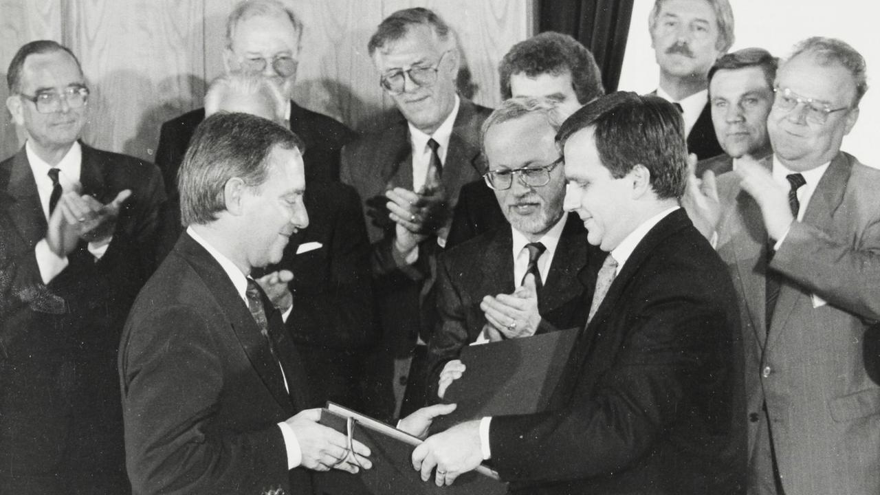 Unterzeichnung des Einigungsvertrags zur Wiedervereinigung der BRD und DDR am 31. August 1990 im Palais Unter den Linden. Bundesinnenminister Wolfgang Schäuble (l) und Staatssekretär Günther Krause überreichen sich die Dokumente. Unterzeichnung des Einigungsvertrags zur Wiedervereinigung der BRD und DDR am 31. August 1990 im Palais Unter den Linden. Bundesinnenminister Wolfgang Schäuble (l) und Staatssekretär Günther Krause überreichen sich die Dokumente.