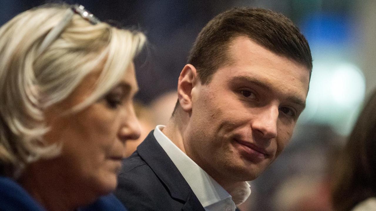 Marine le Pen und Jordan Bardella auf einer Konferenz im Februar, sitzen nebeneinander Marine le Pen und Jordan Bardella auf einer Konferenz im Februar, sitzen nebeneinander