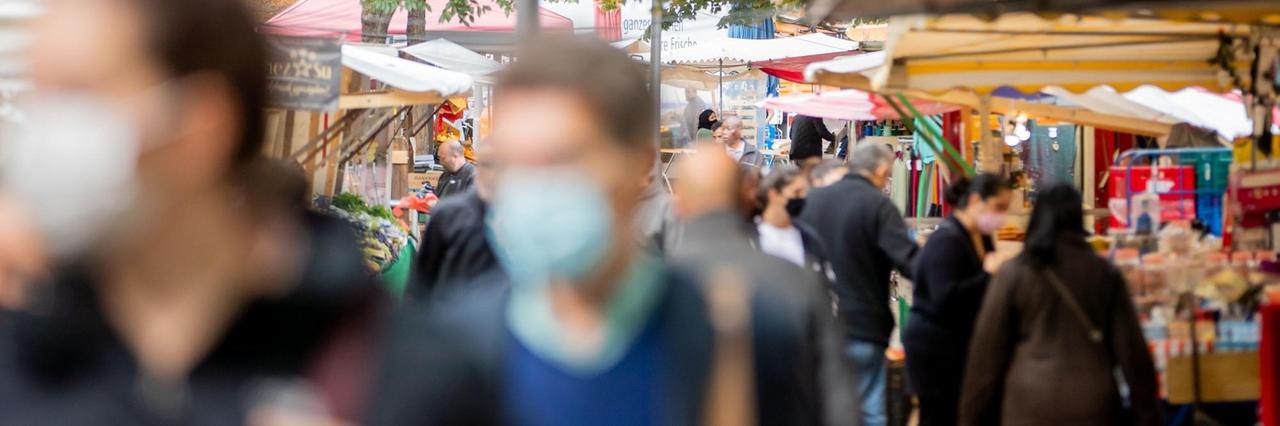 Menschen tragen Mund-Nasen-Bedeckungen und gehen in Berlin-Kreuzberg über den Markt am Maybachufer. Menschen tragen Mund-Nasen-Bedeckungen und gehen in Berlin-Kreuzberg über den Markt am Maybachufer.