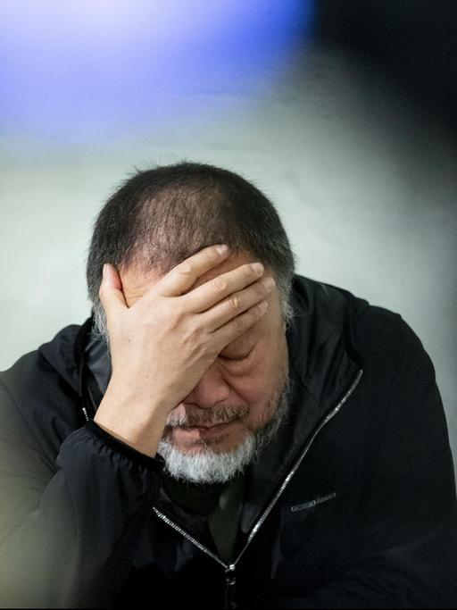 Der chinesische Künstler Ai Weiwei stützt seinen Kopf in eine Hand bei der Präsentation seines Kunstwerks «Safety Jackets Zipped the Other Way» in seinem Atelier.