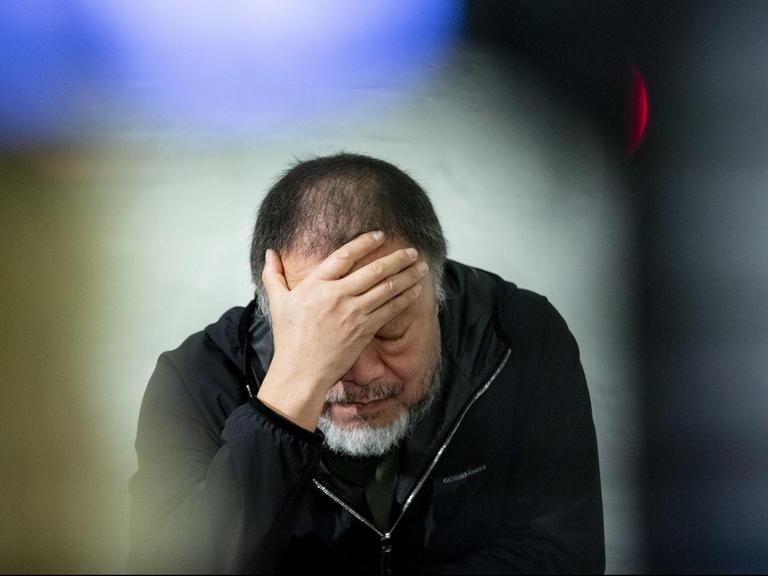 Der chinesische Künstler Ai Weiwei stützt seinen Kopf in eine Hand bei der Präsentation seines Kunstwerks «Safety Jackets Zipped the Other Way» in seinem Atelier.