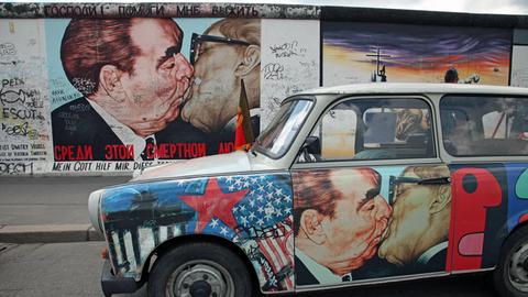 Die "East Side Gallery" ist das größte noch verbliebene Reststück der Berliner Mauer: Das bekannteste Mauerbild ist der "Bruderkuss" zwischen Leonid Breschnew und Erich Honecker, gemalt vom russischen Künstler Dimitri Wrubel.
