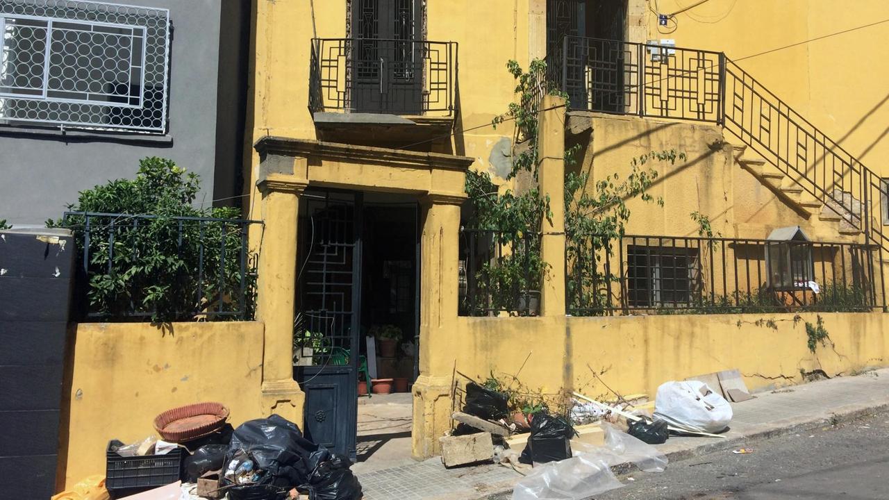 Senfgelbes Haus mit Art Deco in Beirut, davor Zeichen der zerstörerischen Explosion Senfgelbes Haus mit Art Deco in Beirut, davor Zeichen der zerstörerischen Explosion