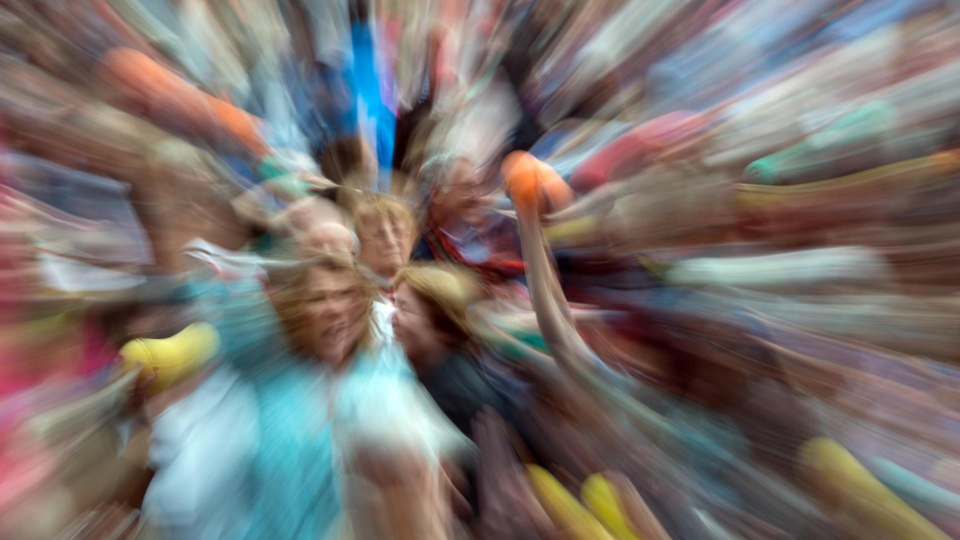 Zuschauer bewegen sich am 19.06.2015 auf dem Marktplatz in Stuttgart (Baden-Württemberg) bei der Auftaktveranstaltung des Tanz-Festivals "Colours" nach einer Mitmach-Choreographie mit dem Titel: "Ball-Passing" (Wischeffekt durch Langzeitbelichtung und Zoom). Bei dem Festival werden verschiedene Choreographien von zahlreichen Kompanien gezeigt. Zusätzlich gibt es Workshops für Amateure und Profis. Foto: Bernd Weißbrod/dpa (zu lsw Meldung: "Tanz für alle mit 7000 Bällen - Gauthier wirbt für «Colours»-Festival" vom 19.06.2014) | Verwendung weltweit Zuschauer bewegen sich am 19.06.2015 auf dem Marktplatz in Stuttgart (Baden-Württemberg) bei der Auftaktveranstaltung des Tanz-Festivals "Colours" nach einer Mitmach-Choreographie mit dem Titel: "Ball-Passing" (Wischeffekt durch Langzeitbelichtung und Zoom). Bei dem Festival werden verschiedene Choreographien von zahlreichen Kompanien gezeigt. Zusätzlich gibt es Workshops für Amateure und Profis. Foto: Bernd Weißbrod/dpa (zu lsw Meldung: "Tanz für alle mit 7000 Bällen - Gauthier wirbt für «Colours»-Festival" vom 19.06.2014) | Verwendung weltweit