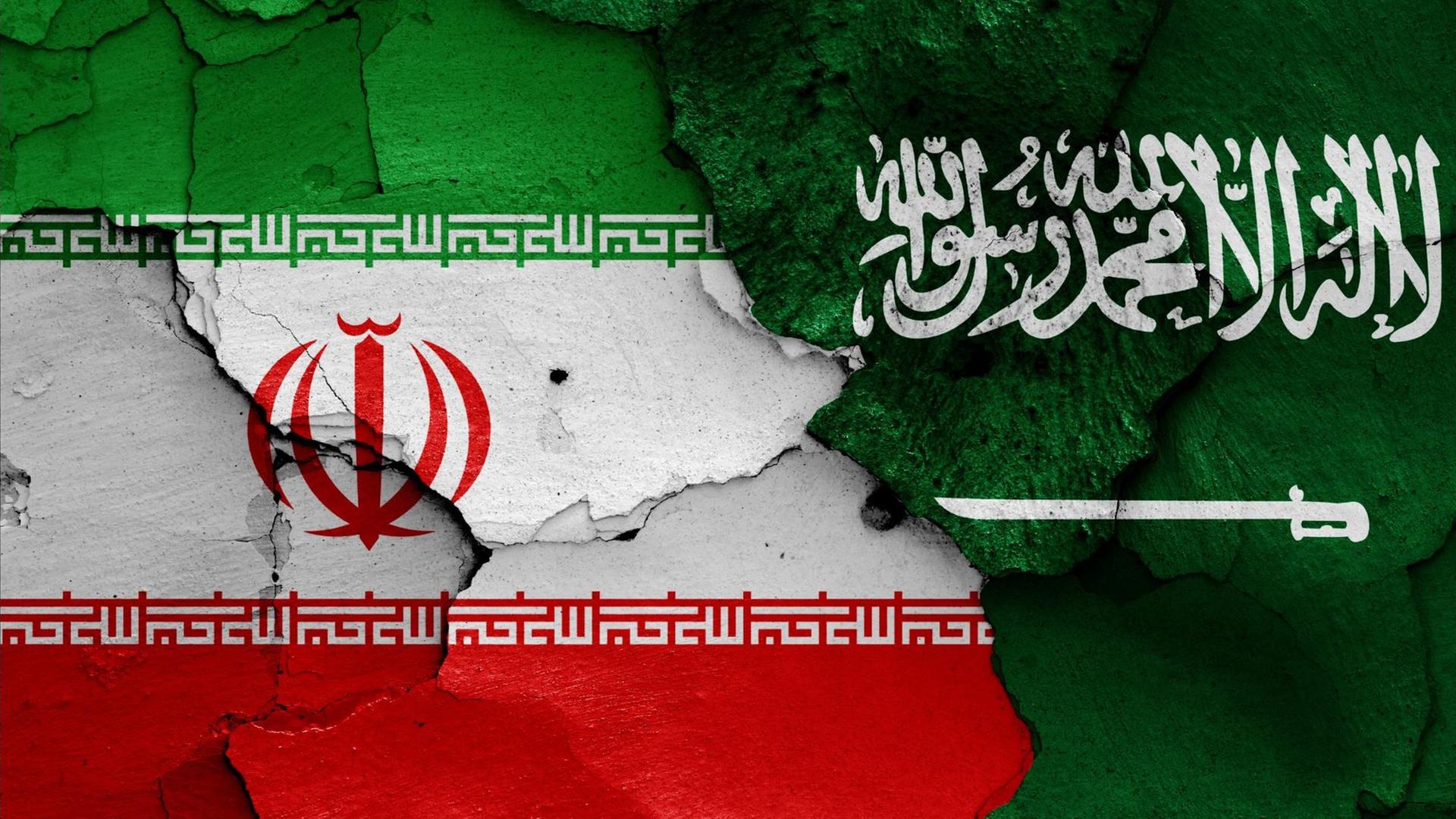 Die Flaggen von Iran und Saudi-Arabien sind auf eine bröckelnde Wand gemalt Die Flaggen von Iran und Saudi-Arabien sind auf eine bröckelnde Wand gemalt