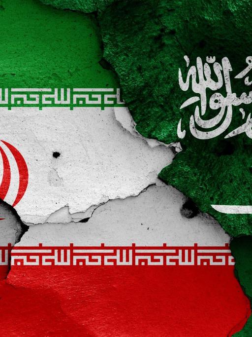 Die Flaggen von Iran und Saudi-Arabien sind auf eine bröckelnde Wand gemalt
