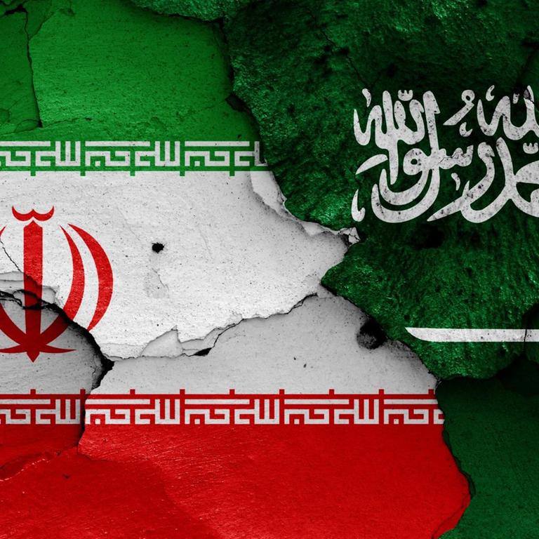 Die Flaggen von Iran und Saudi-Arabien sind auf eine bröckelnde Wand gemalt