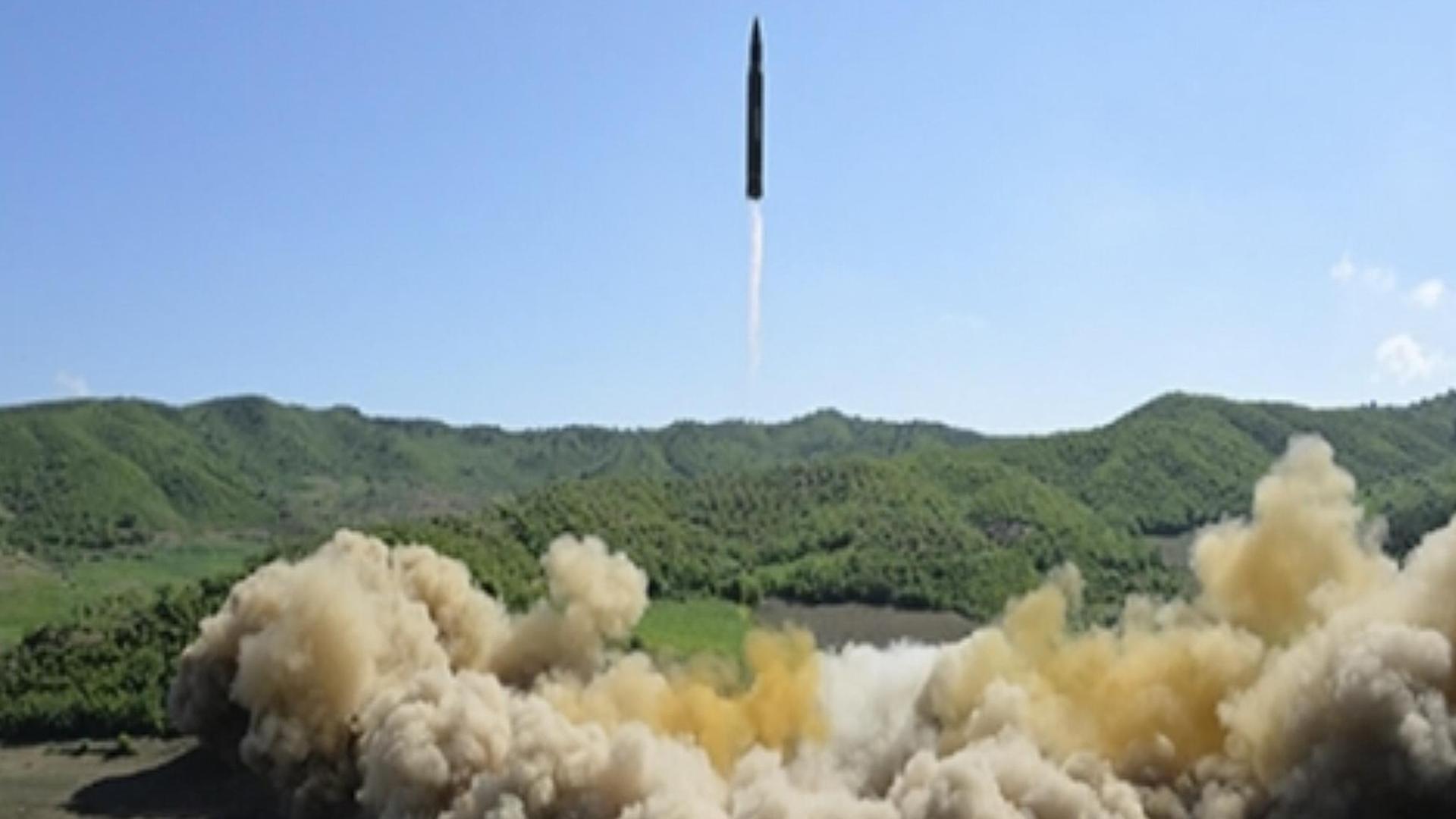Über grünen Hügeln steigt eine Rakete gerade in den Himmel. Über grünen Hügeln steigt eine Rakete gerade in den Himmel.