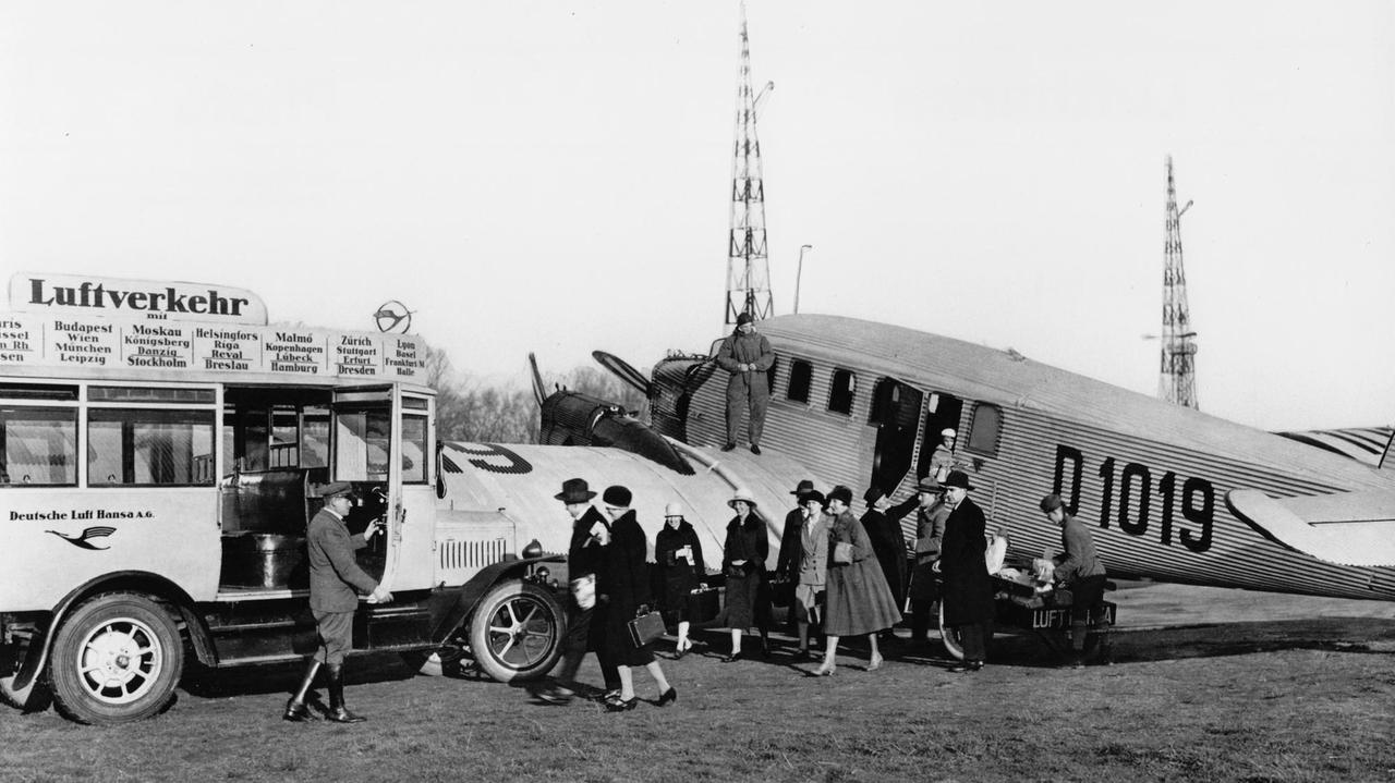 Passagiere steigen aus einem Flugzeug um in einen direkt daneben parkenden Bus. Passagiere steigen aus einem Flugzeug um in einen direkt daneben parkenden Bus.