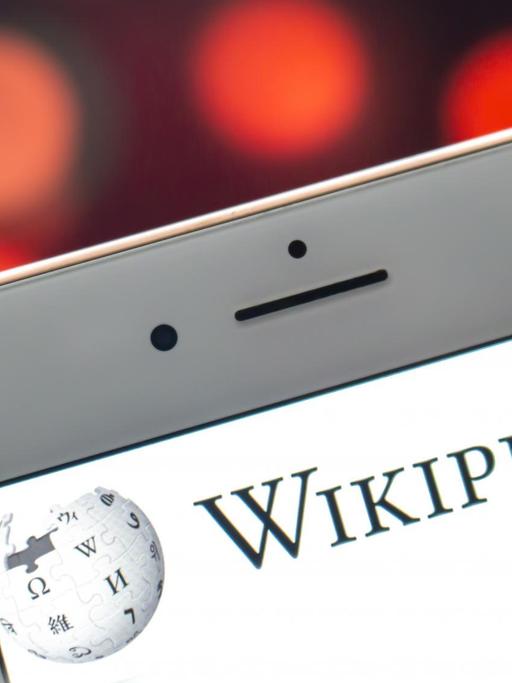 Das Wikipedia-Logo auf einem iPhone-Display.