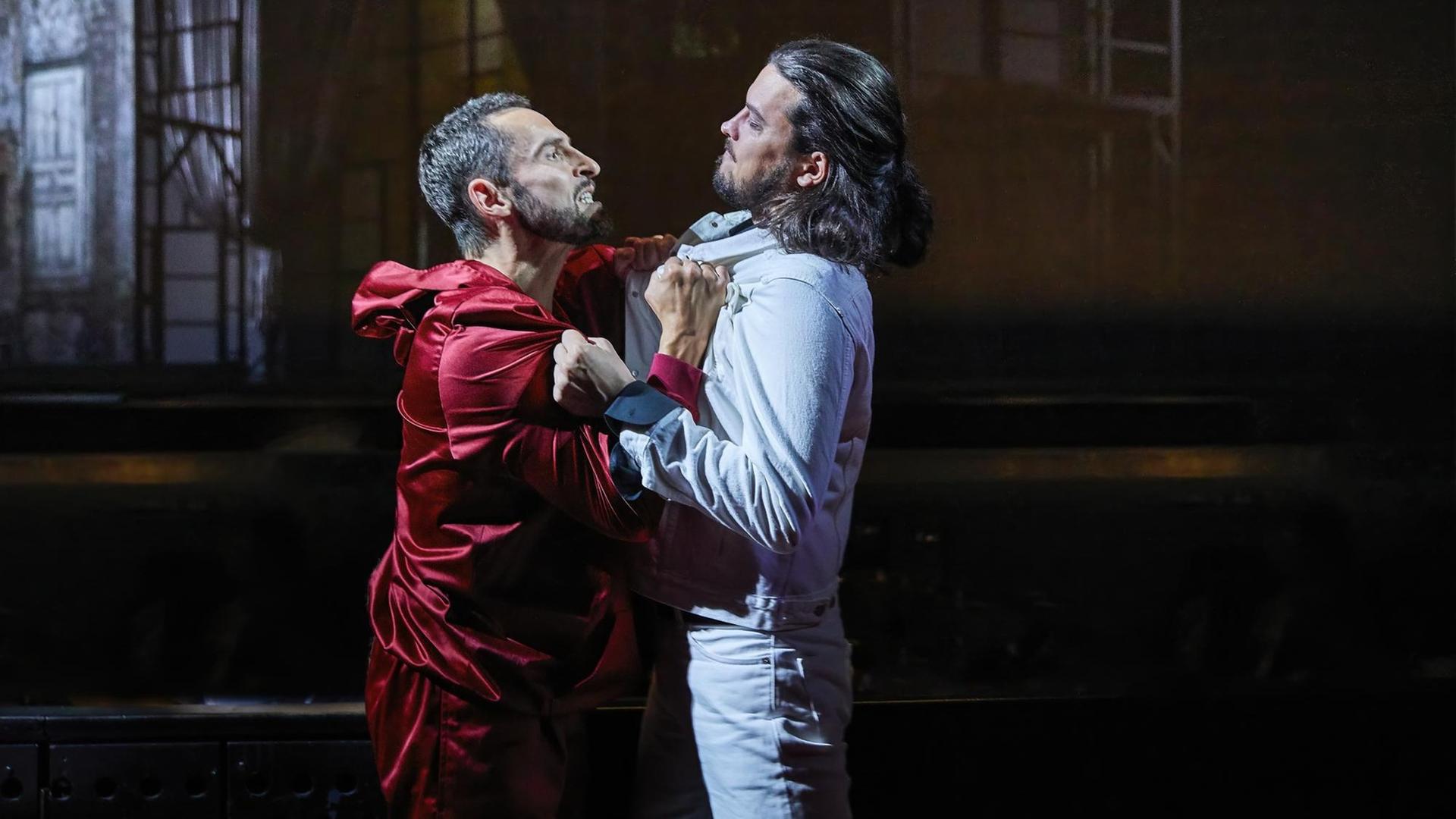 Leporello packt Don Giovanni am Kragen und sieht ihn bedrohlich an. Leporello packt Don Giovanni am Kragen und sieht ihn bedrohlich an.
