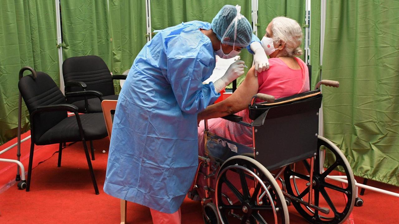 Indien: Eine Frau im Rollstuhl wird geimpft. Indien: Eine Frau im Rollstuhl wird geimpft.