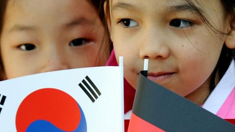 Südkoreanische Kinder mit Papierfahnen warten am 9.5.2011 im Schloss Bellevue in Berlin auf den südkoreanischen Präsidenten Lee Myung Bak und seine Frau Kim Yoon-ok.