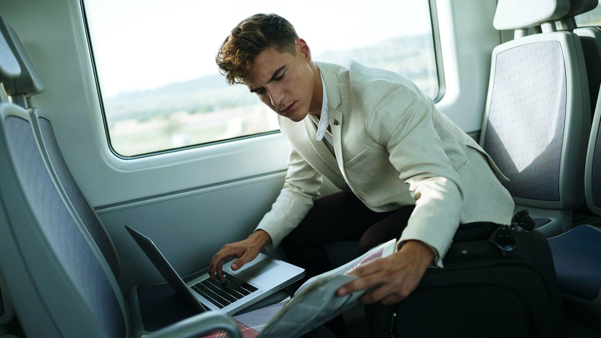 Ein junger Mann arbeitet im Zug