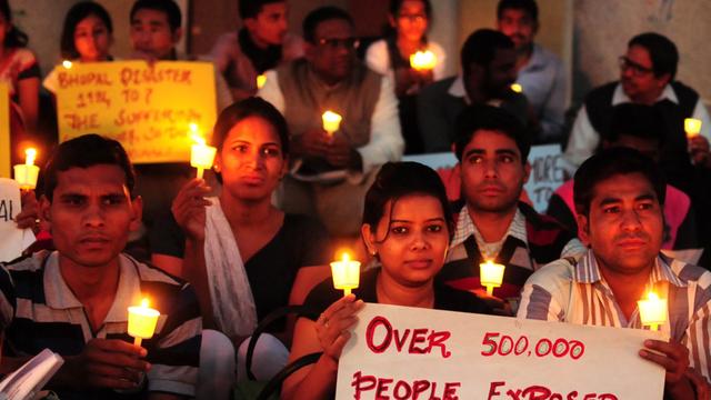 Mitglieder einer Nichtregierungsorganisation halten Plakate und Kerzen während des 30.Jahrestages der Bhopal-Katastrophe.