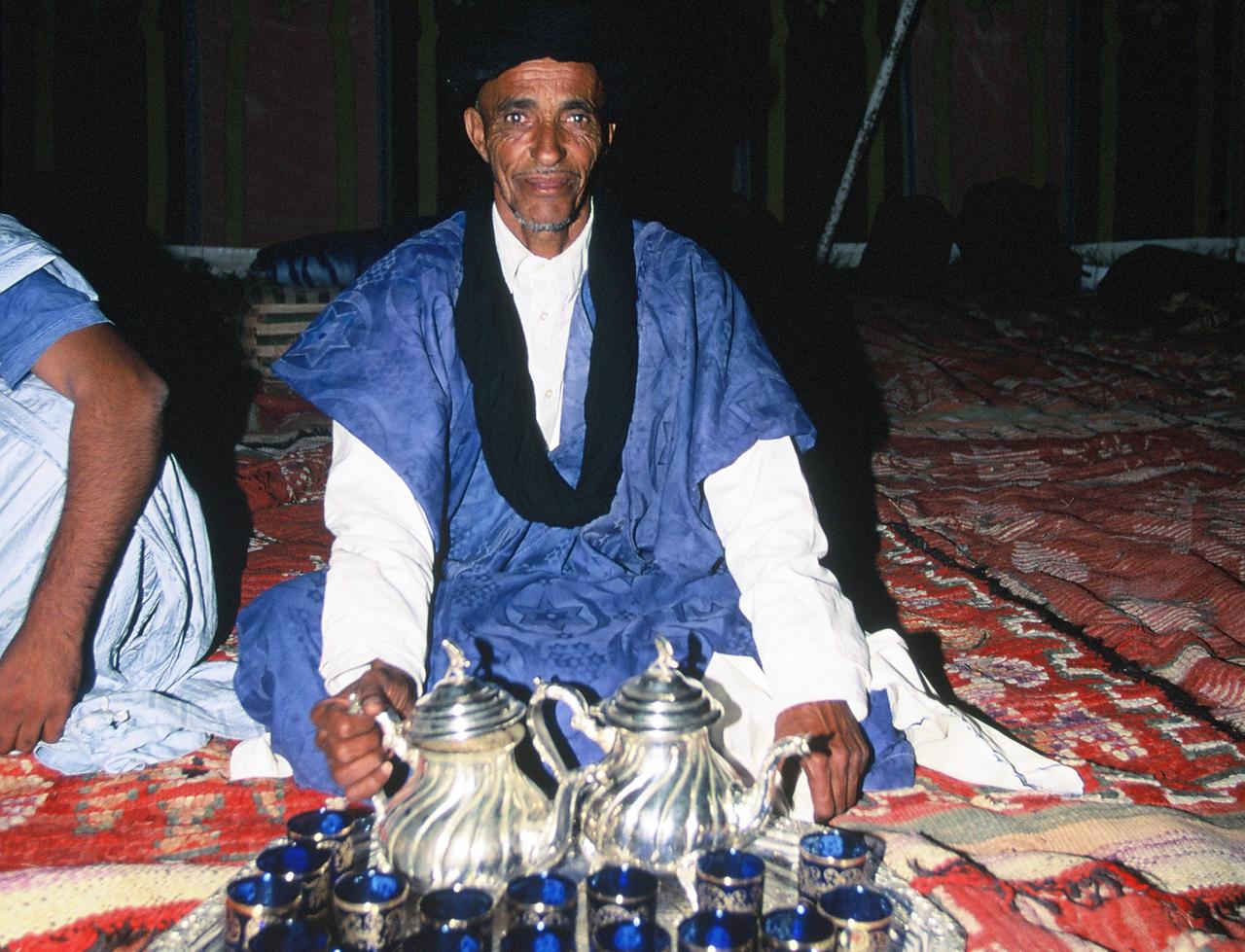 Marokkanische Teezeremonie bei Nomaden in traditionellem Gewand in der Sahara in Marokko.
