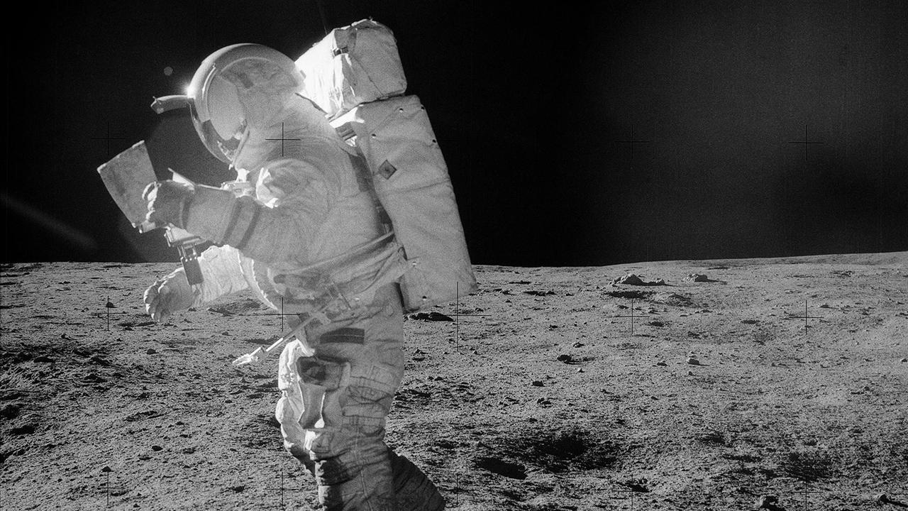 Edgar Mitchell guckt auf die Karte, um den Weg zum Cone-Krater zu finden Edgar Mitchell guckt auf die Karte, um den Weg zum Cone-Krater zu finden