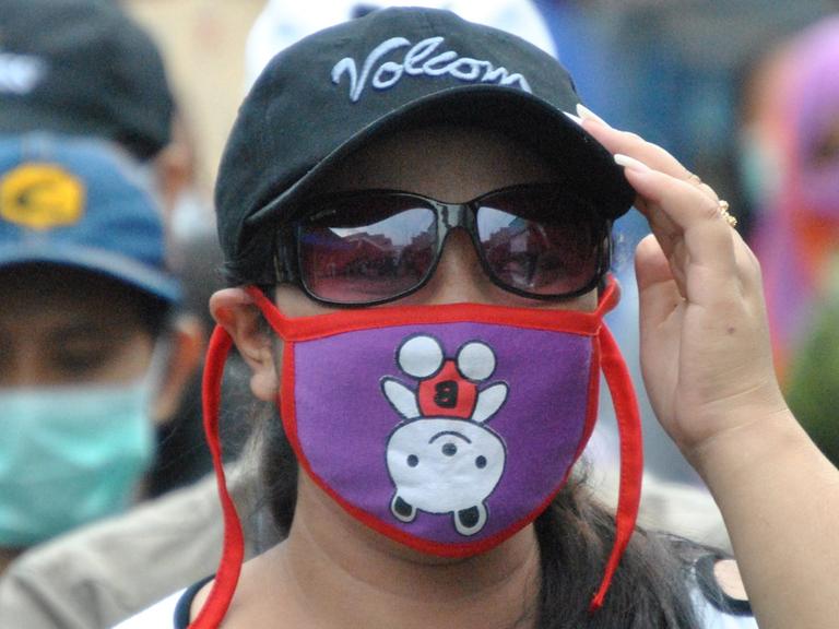 Vermummte Demonstrantin, die gegen die Schließung des Rotlicht-Viertels im indonesischen Surabaya protestiert.