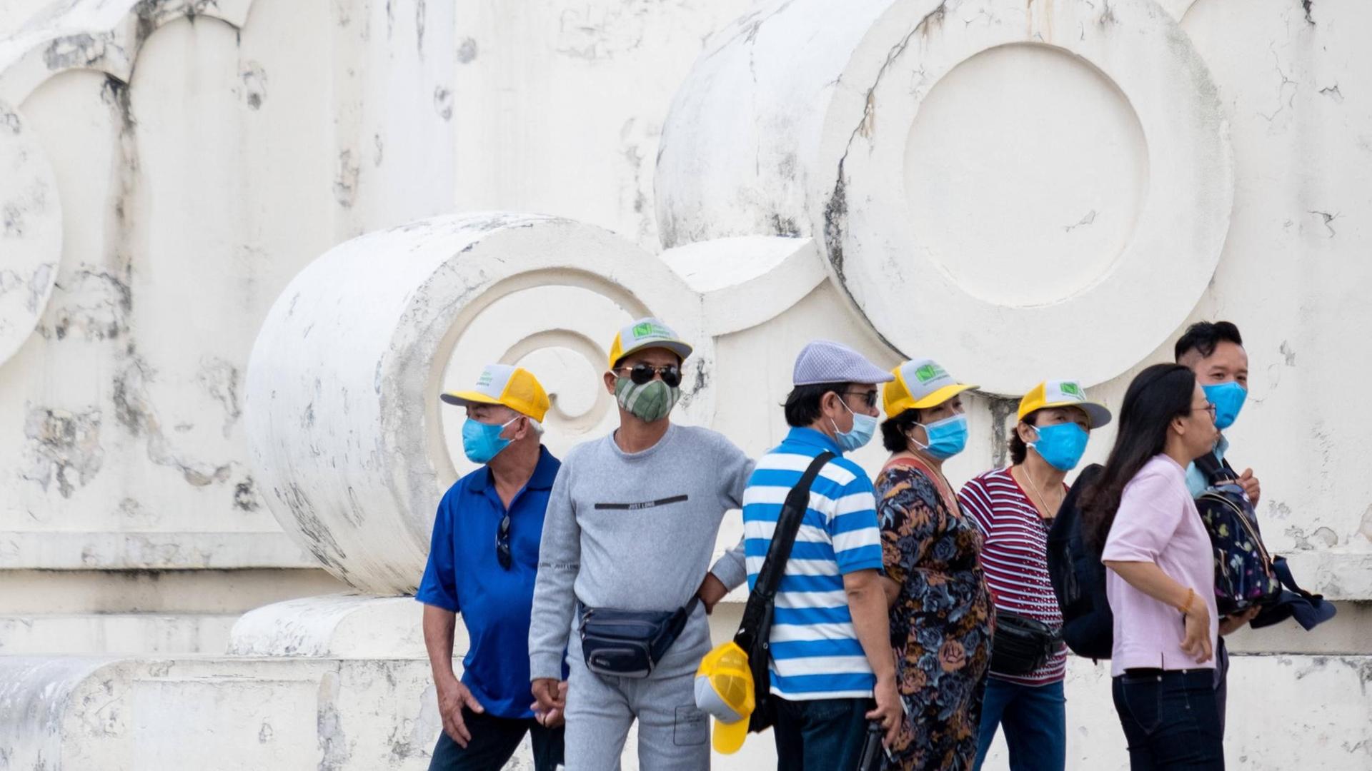 Eine Touristengruppe in Taiwan in Freizeitkleidung und mit chirurgischen Gesichtsschutzmasken. Eine Touristengruppe in Taiwan in Freizeitkleidung und mit chirurgischen Gesichtsschutzmasken.