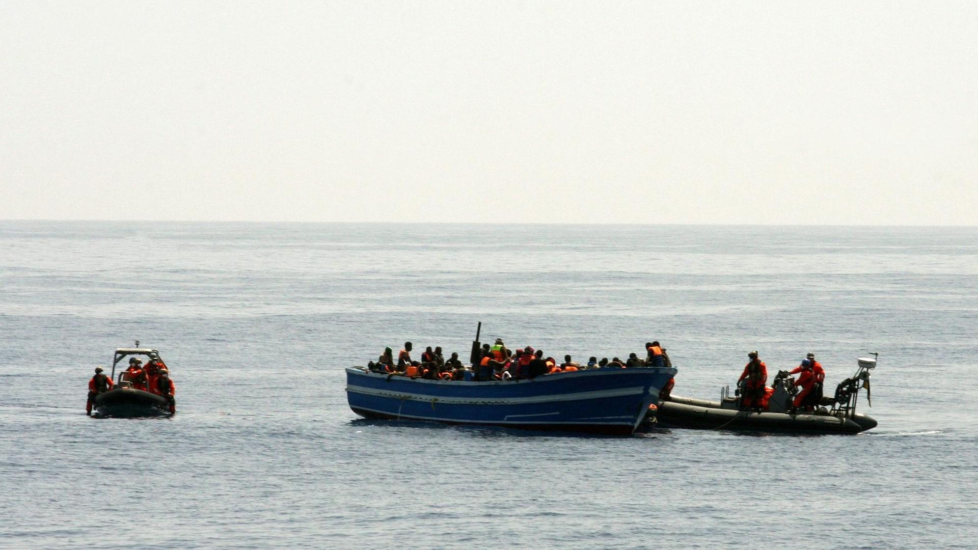 Bundeswehr-Soldaten auf einem kleinen Motorboot bergen im Mittelmeer Schiffbrüchige von einem Holzboot. Bundeswehr-Soldaten auf einem kleinen Motorboot bergen im Mittelmeer Schiffbrüchige von einem Holzboot.
