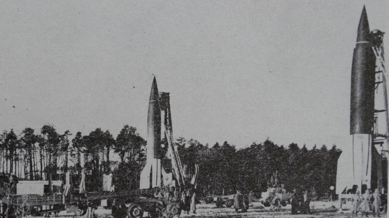 Schwarz-Weiß Fotografie, die drei Raketen auf einem Feld zeigt.
