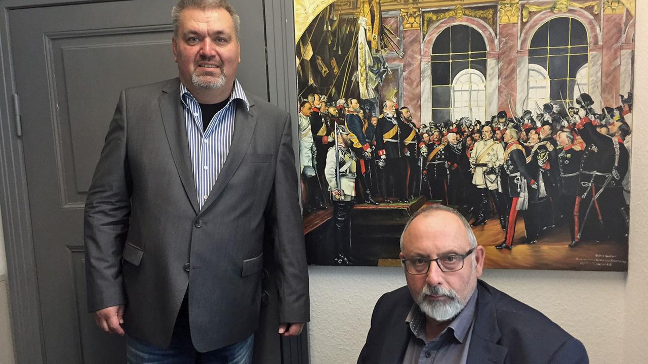 Bernhard Wildt, der BMV-Fraktionschef, und Ralf Borschke (rechts) vor der von Borschke gemalten Kopie des Werner-Gemäldes "Die Proklamation des Deutschen Kaiserreiches" Bernhard Wildt, der BMV-Fraktionschef, und Ralf Borschke (rechts) vor der von Borschke gemalten Kopie des Werner-Gemäldes "Die Proklamation des Deutschen Kaiserreiches"