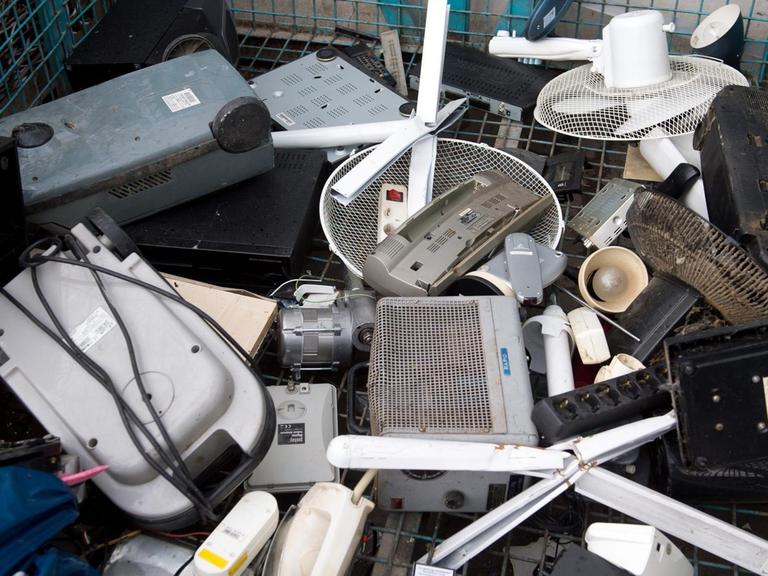 Man sieht alte Elektrogeräte auf einem Recyclinghof in einem Behälter für Elektroschrott.