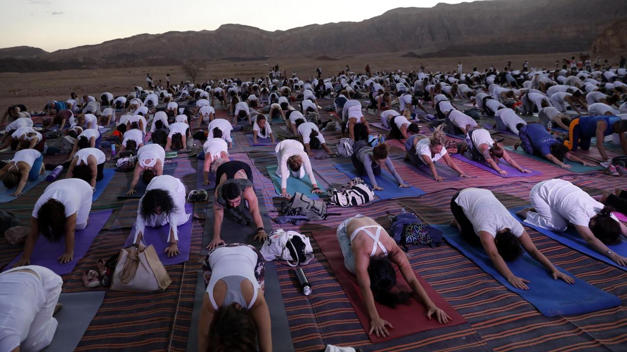 Menschen üben in der Arava Wüste in Israel Yoga. Menschen üben in der Arava Wüste in Israel Yoga.