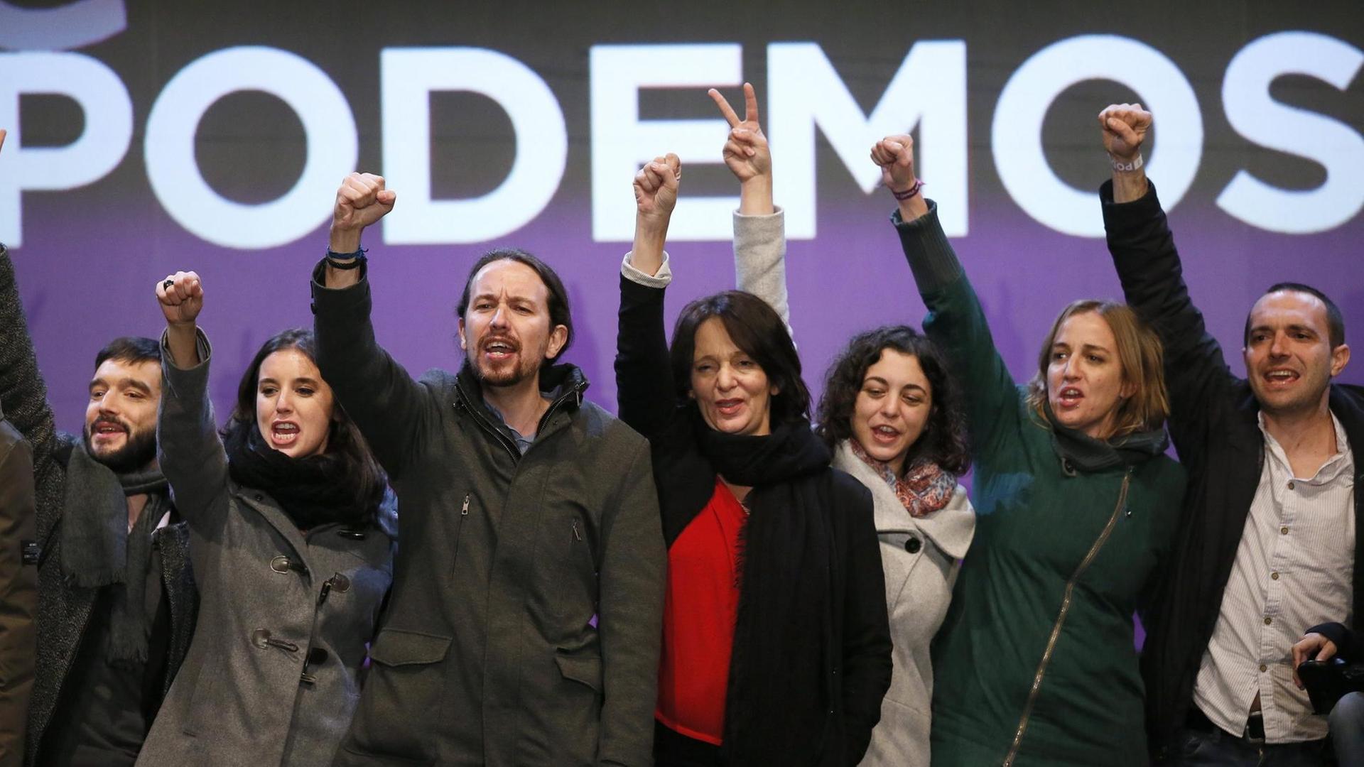 Zu sehen in einer Reihe sind Mitglieder der Partei "Podemos", die ihre Arme in die Luft recken. Auch Parteichef Pablo Iglesias ist dabei (dritter von links). Zu sehen in einer Reihe sind Mitglieder der Partei "Podemos", die ihre Arme in die Luft recken. Auch Parteichef Pablo Iglesias ist dabei (dritter von links).