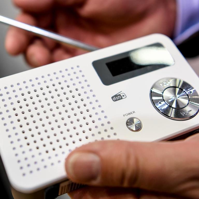 An employee holds a digital radio with DAB + at the IFA technology fair, the world's largest entertainment and consumer electronics fair.