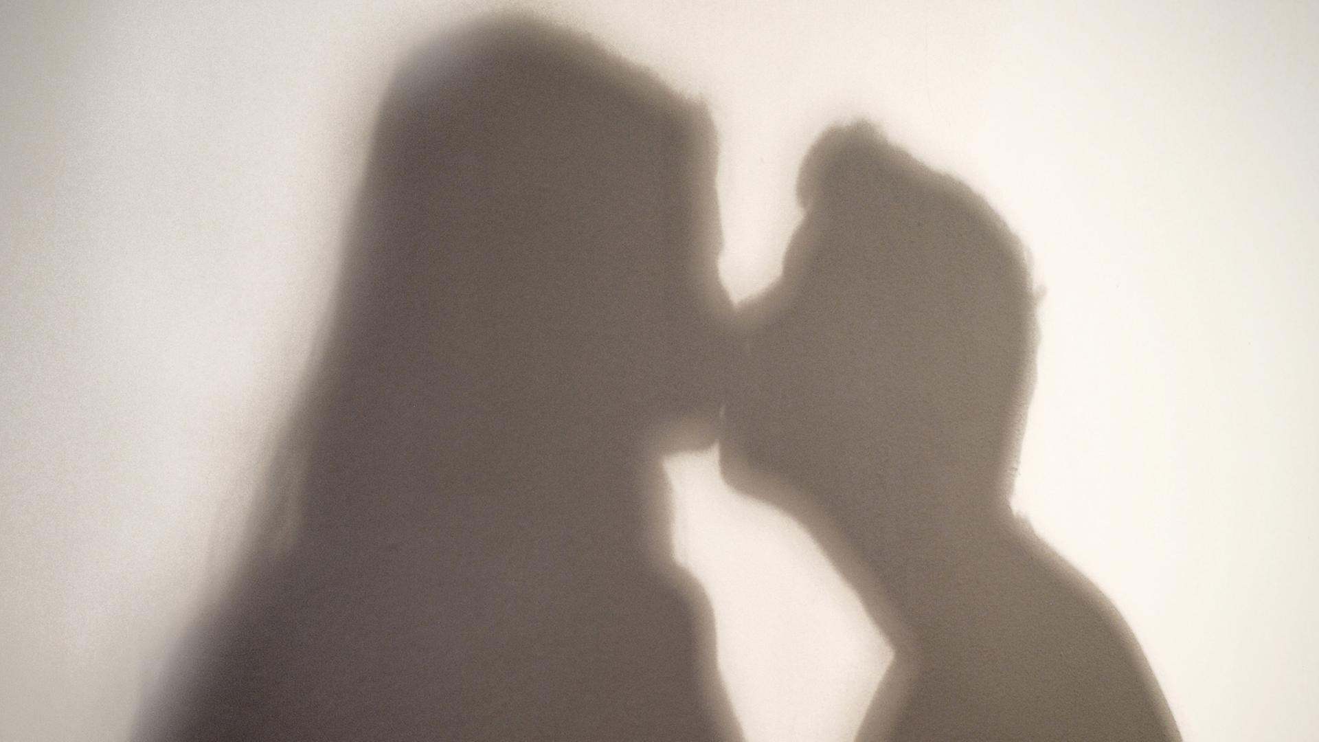 Der Schatten einer Frau und eines Mannes, die sich küssen. Der Schatten einer Frau und eines Mannes, die sich küssen.