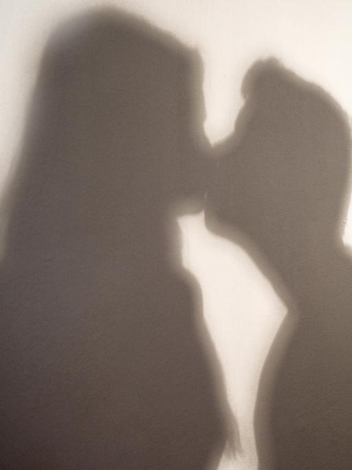 Der Schatten einer Frau und eines Mannes, die sich küssen.