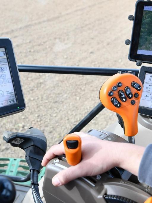 Ein Landwirt fährt einen Traktor, der mit Hilfe von GPS gesteuert wird