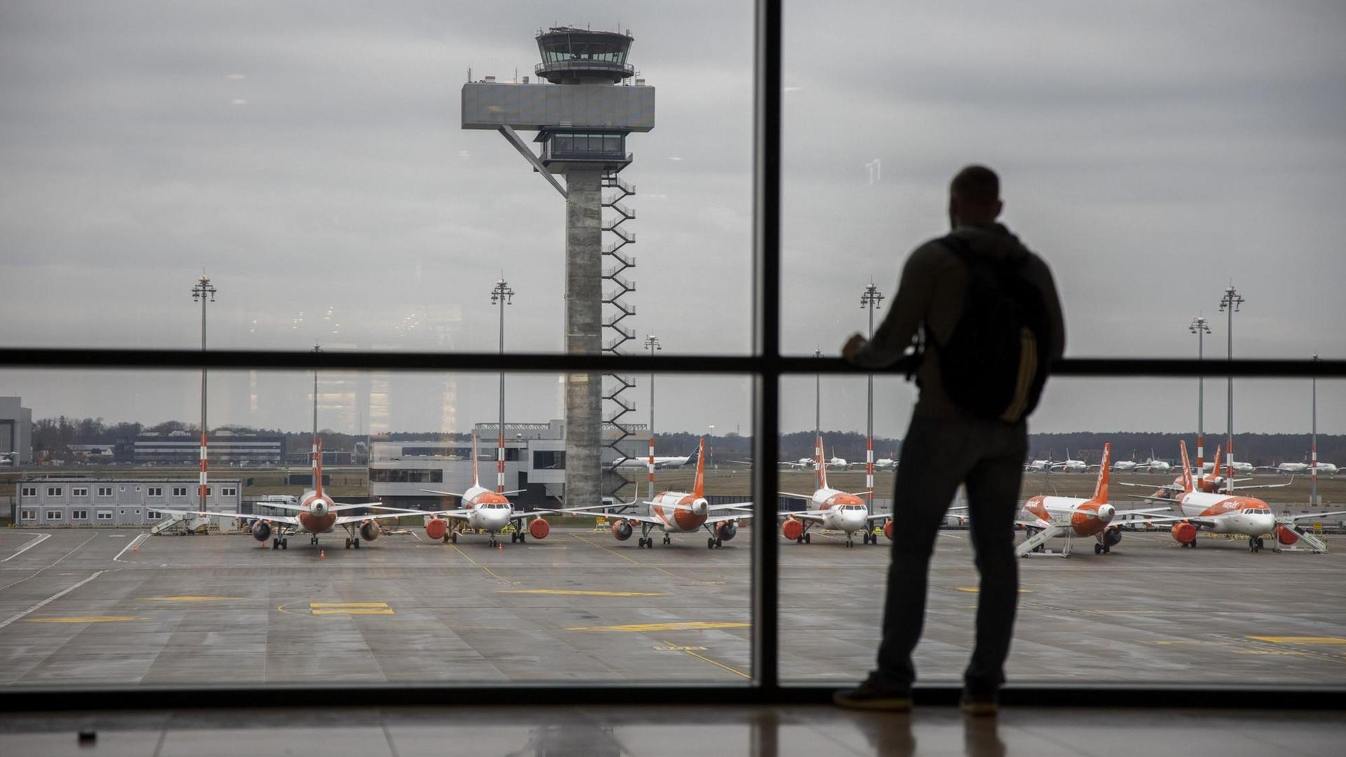 Ein Fluggast im Wartebereich des Terminals vom Flughafen Berlin-Brandenburg.
