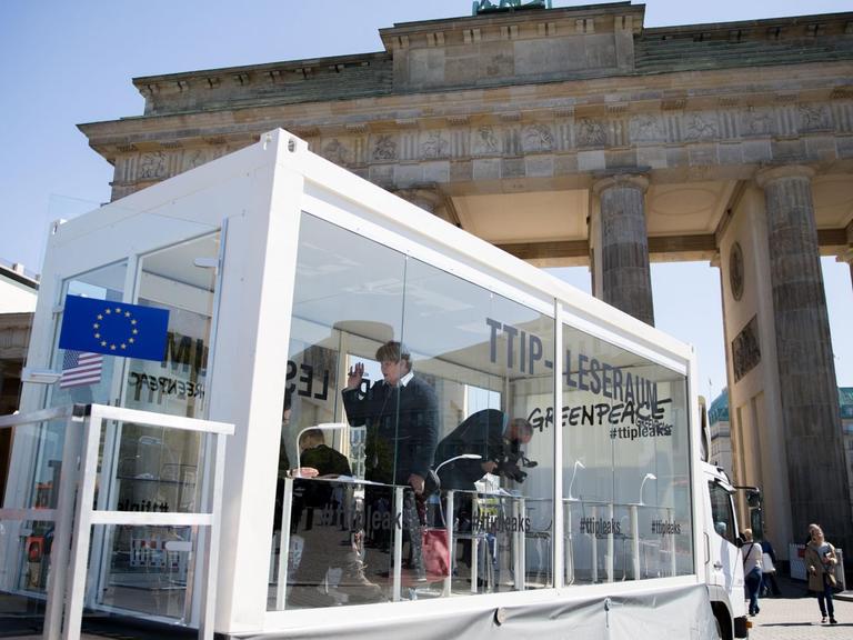 Bürger lesen am 02.05.2016 in Berlin am Brandenburger Tor in einem gläsernen Leseraum in den von Greenpeace veröffentlichten TTIP-Dokumenten.