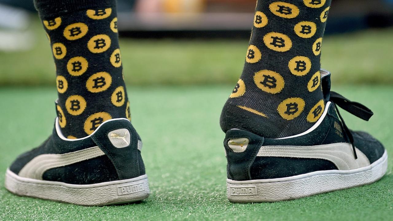 Ein junger Mann trägt am 4.11.2018 beim LA Summit 2018 Socken mit Bitcoin-Werbung. Ein junger Mann trägt am 4.11.2018 beim LA Summit 2018 Socken mit Bitcoin-Werbung.