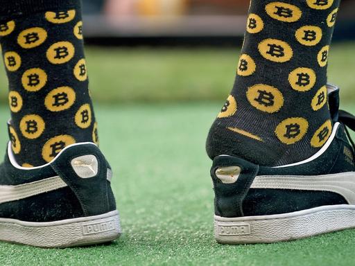 Ein junger Mann trägt am 4.11.2018 beim LA Summit 2018 Socken mit Bitcoin-Werbung.
