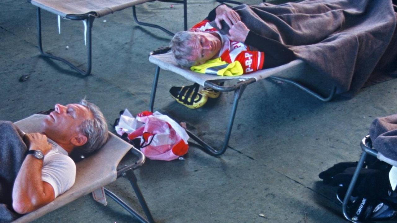 Teilnehmer des Radmarathons haben sich in einem Schlafsaal auf Feldbetten hingelegt. Teilnehmer des Radmarathons haben sich in einem Schlafsaal auf Feldbetten hingelegt.
