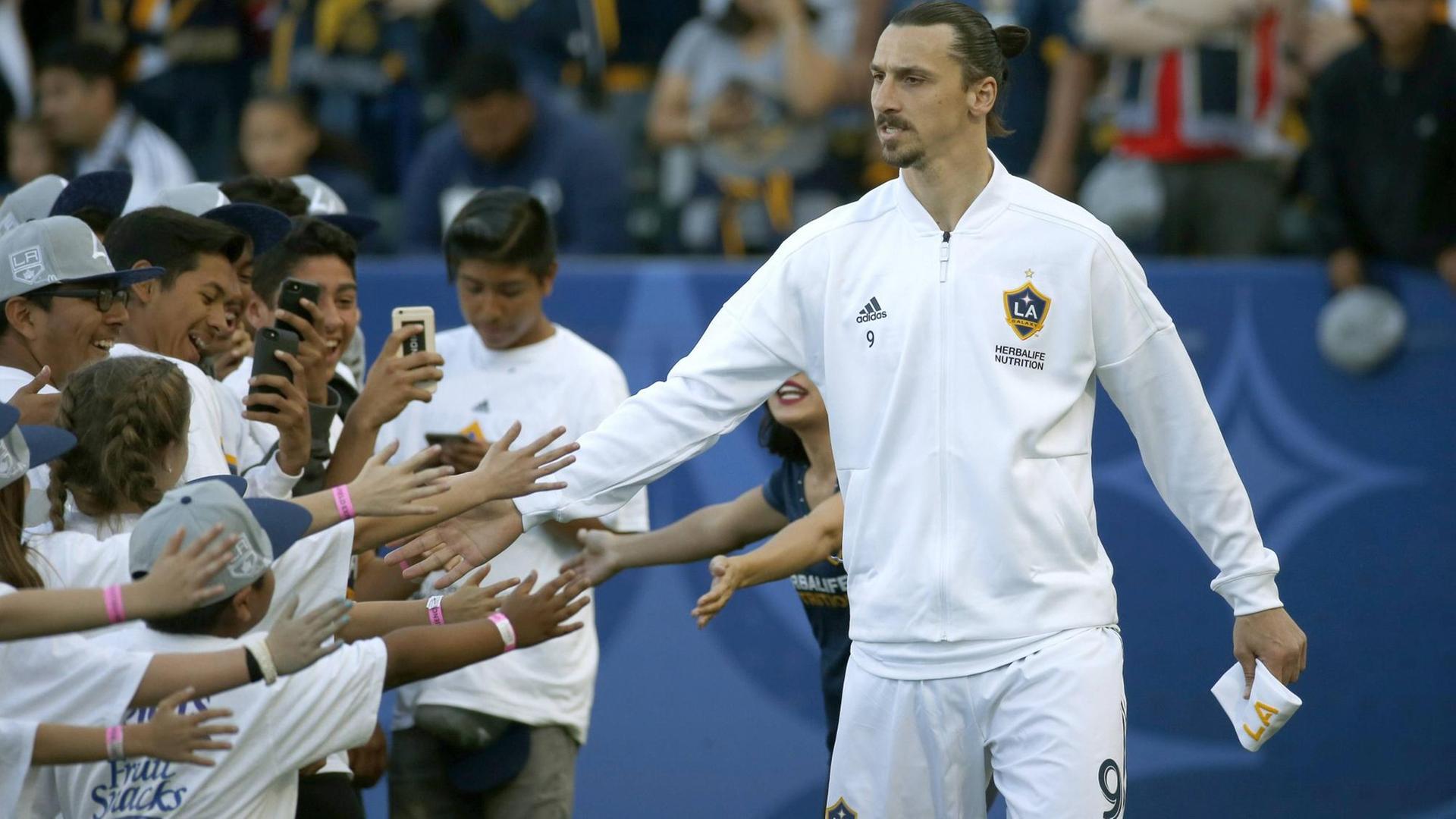 Zlatan Ibrahimovic wird von einer Gruppe junger Fans belagert. Zlatan Ibrahimovic wird von einer Gruppe junger Fans belagert.